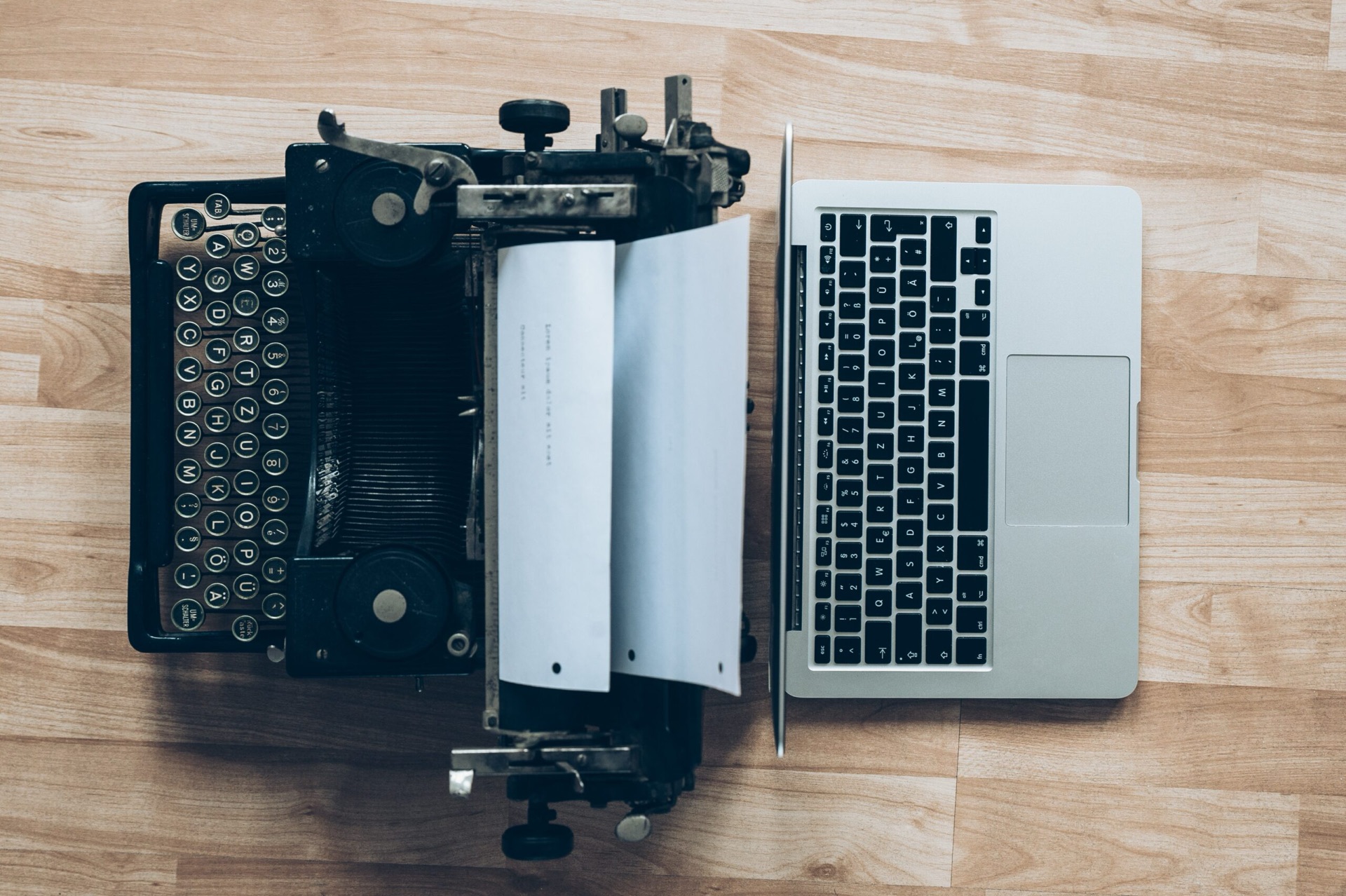 A typewriter beside a laptop on a desk
